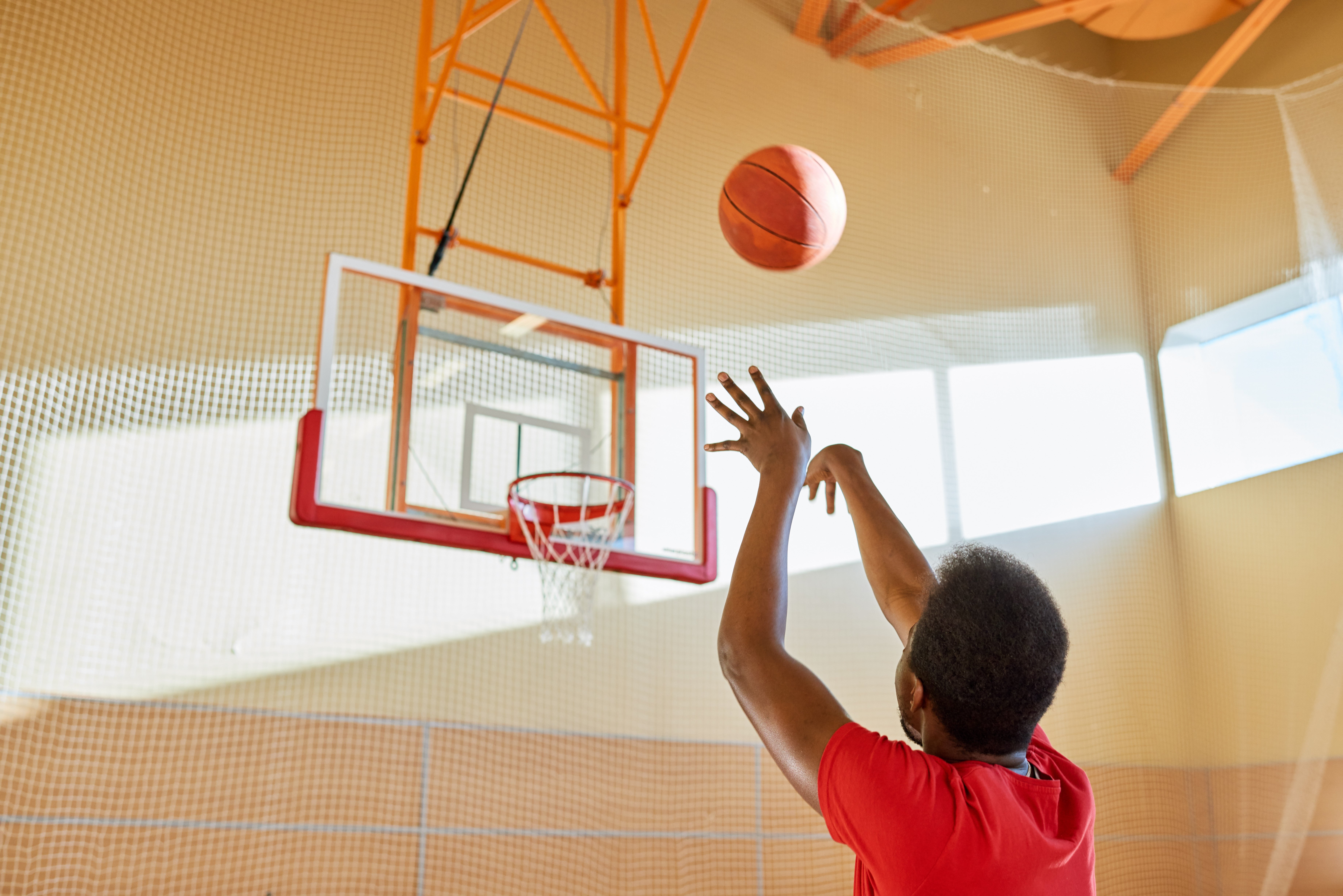 tall-african-man-shooting-ball-court